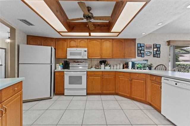 kitchen featuring a textured ceiling, white appliances, a tray ceiling, sink, and ceiling fan