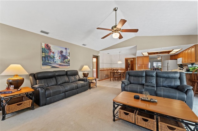 carpeted living room featuring ceiling fan and vaulted ceiling