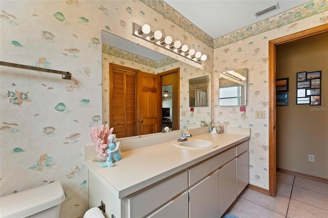 bathroom with vanity, toilet, and tile patterned floors