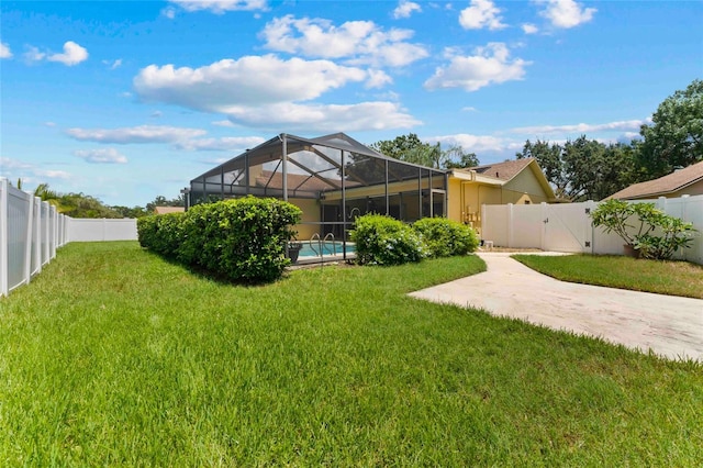 view of yard featuring a fenced in pool and glass enclosure