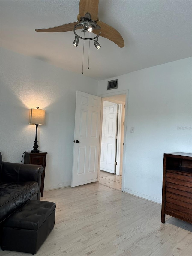 living room with ceiling fan and light wood-type flooring