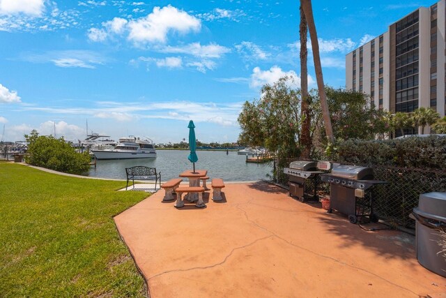 view of patio / terrace featuring a water view, a dock, and grilling area