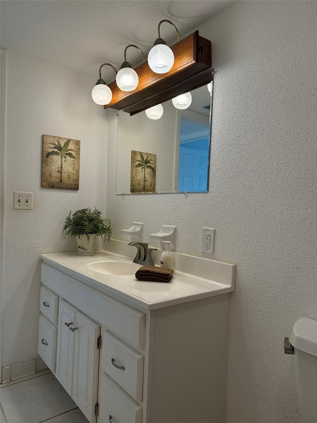 bathroom with toilet, tile patterned flooring, and vanity