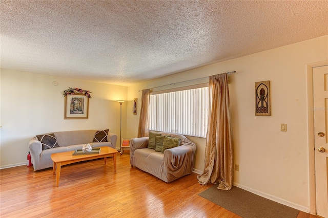 living room featuring a textured ceiling and light hardwood / wood-style floors