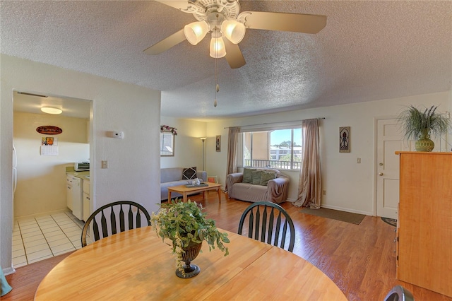 dining room featuring ceiling fan, a textured ceiling, and light wood-type flooring