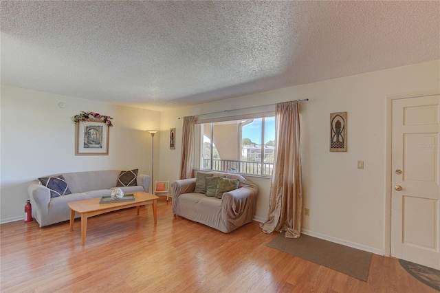 living room with a textured ceiling and light wood-type flooring