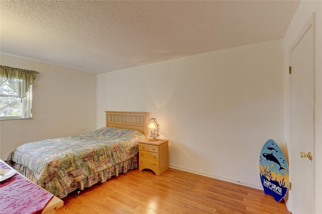 bedroom featuring hardwood / wood-style floors and a textured ceiling