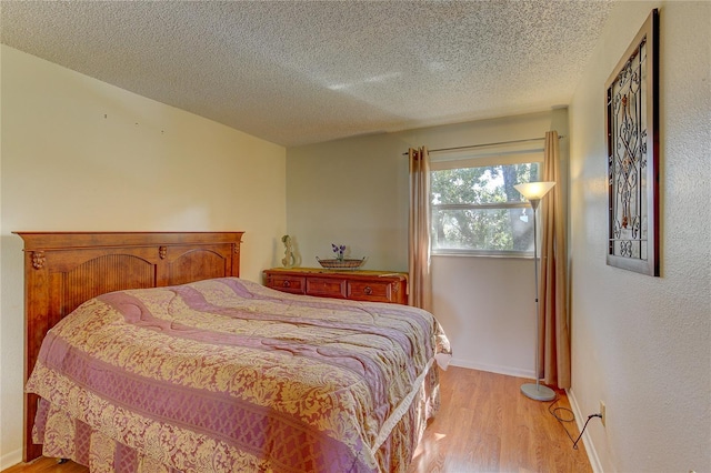 bedroom featuring light hardwood / wood-style flooring and a textured ceiling