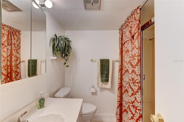 bathroom with tile patterned floors, toilet, vanity, a textured ceiling, and walk in shower