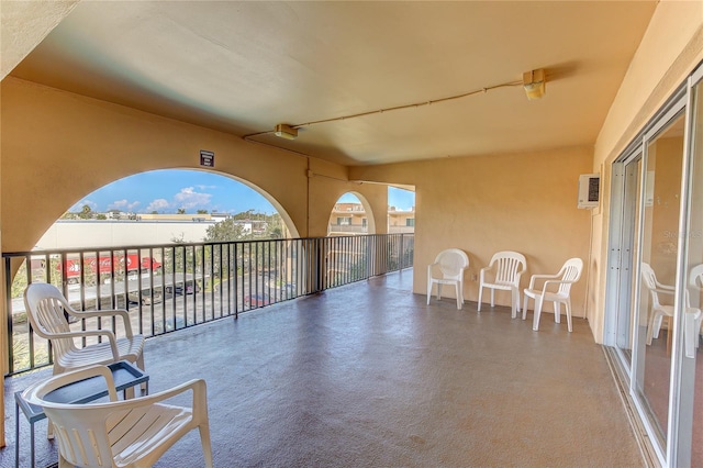 view of patio with a balcony and a wall mounted AC