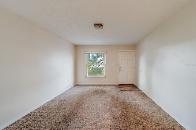 spare room with a textured ceiling and carpet floors