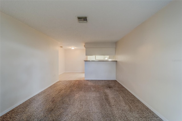 unfurnished room with light carpet and a textured ceiling