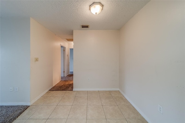 tiled spare room with a textured ceiling