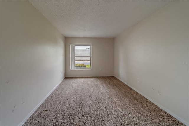 carpeted spare room with a textured ceiling