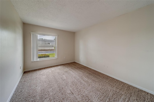 empty room featuring a textured ceiling and carpet floors