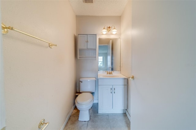 bathroom featuring tile patterned flooring, toilet, a textured ceiling, and vanity