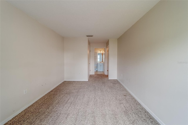 unfurnished room with a textured ceiling and carpet floors