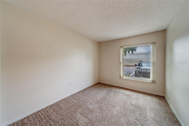 carpeted empty room with a textured ceiling