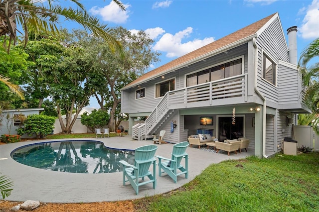 back of property featuring outdoor lounge area, a patio area, and a lawn