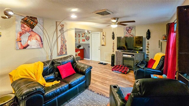 living room with wood-type flooring and ceiling fan