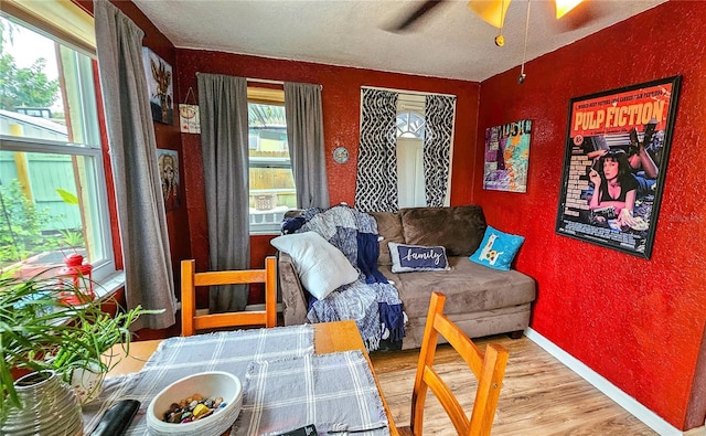 living room with ceiling fan, a textured ceiling, plenty of natural light, and hardwood / wood-style floors