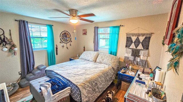 bedroom featuring a textured ceiling, wood-type flooring, and ceiling fan