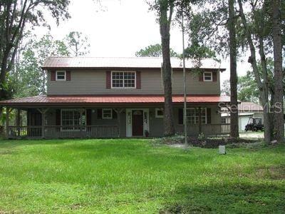 back of house featuring a porch and a yard