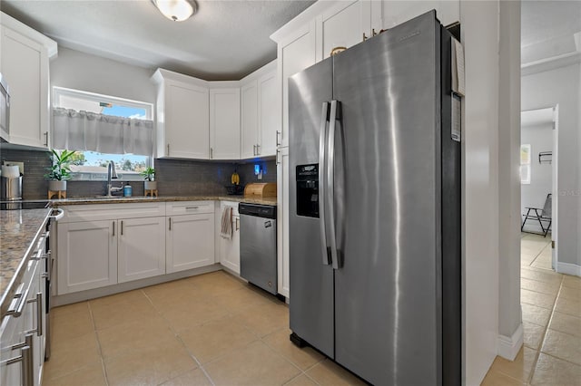 kitchen featuring white cabinetry, stainless steel appliances, and decorative backsplash