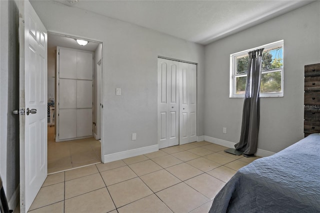 tiled bedroom with a closet and a textured ceiling