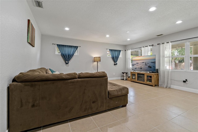 living room with a textured ceiling and light tile patterned flooring