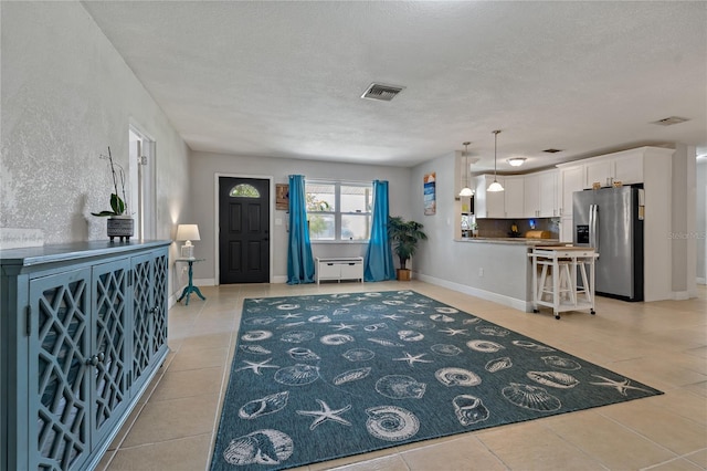 tiled entryway featuring a textured ceiling