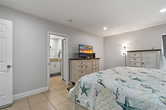 bedroom with light tile patterned floors and ensuite bath