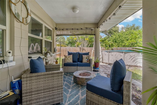 view of patio with an outdoor living space with a fire pit and a fenced in pool