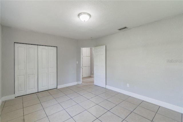 unfurnished bedroom featuring light tile patterned flooring and a closet