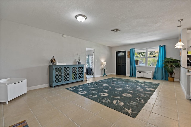 tiled entryway featuring a textured ceiling