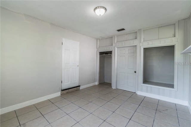 unfurnished bedroom with a closet and light tile patterned flooring