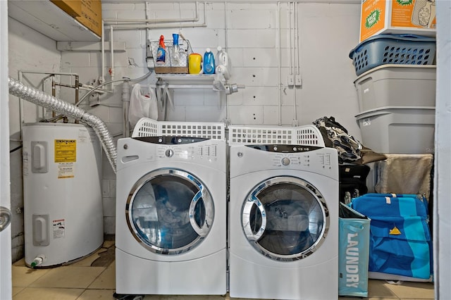 clothes washing area featuring water heater, washer and dryer, and tile patterned flooring