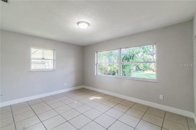 tiled spare room with a textured ceiling