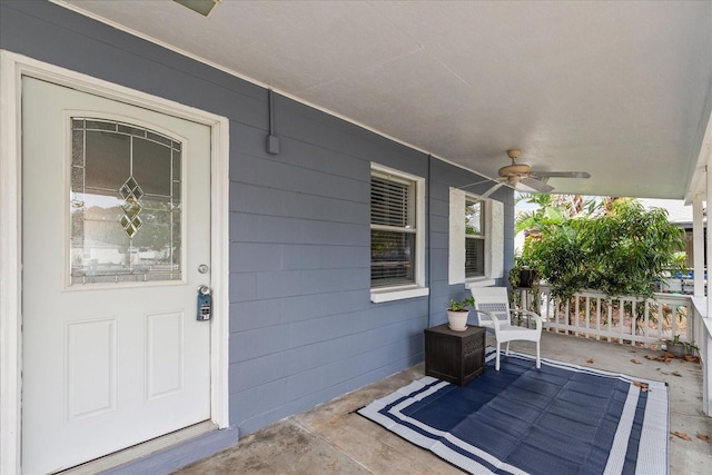 view of exterior entry featuring covered porch and ceiling fan