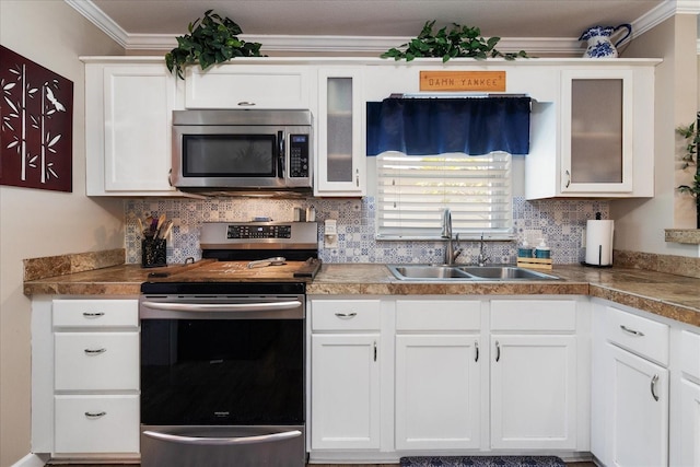 kitchen with white cabinetry, sink, ornamental molding, and appliances with stainless steel finishes