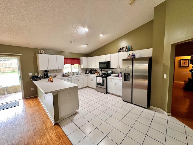 kitchen with kitchen peninsula, appliances with stainless steel finishes, decorative backsplash, high vaulted ceiling, and white cabinetry