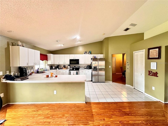 kitchen with white cabinetry, stainless steel appliances, light hardwood / wood-style flooring, kitchen peninsula, and a textured ceiling