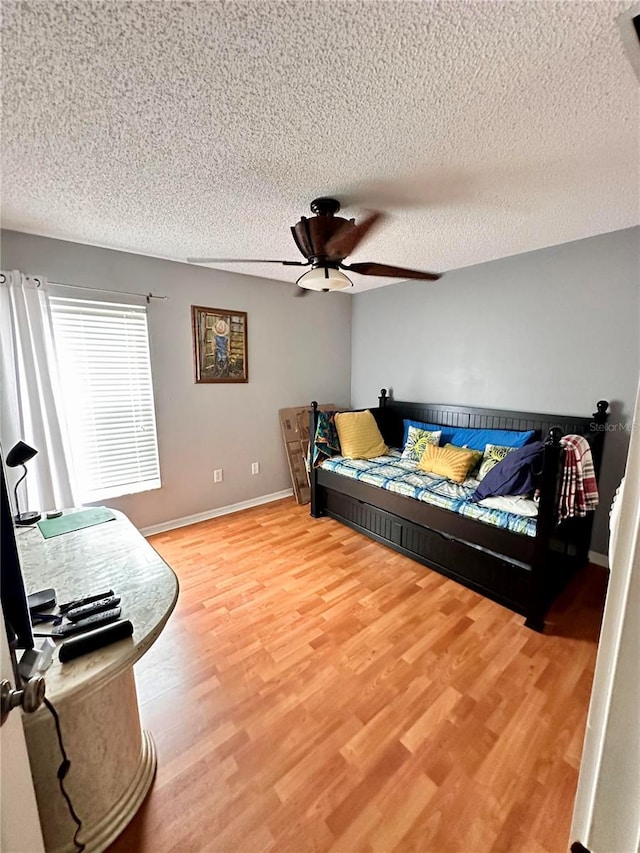 living room with hardwood / wood-style floors, ceiling fan, and a textured ceiling