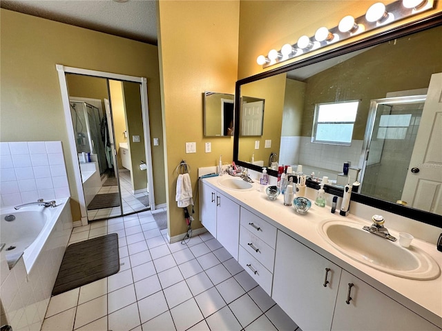 bathroom with tile patterned floors, vanity, a textured ceiling, and shower with separate bathtub