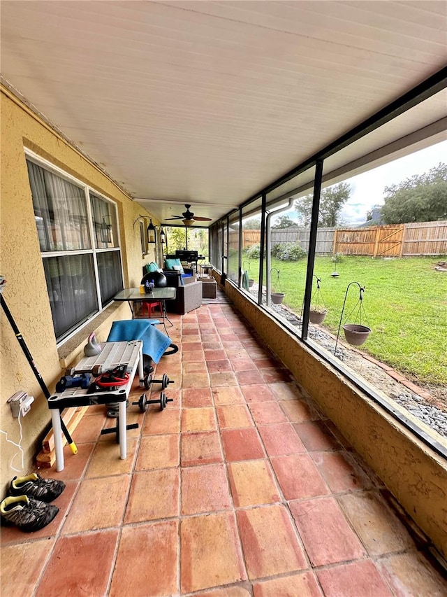 sunroom / solarium featuring ceiling fan