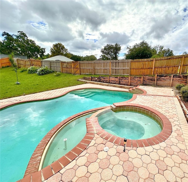 view of pool with a lawn and an in ground hot tub