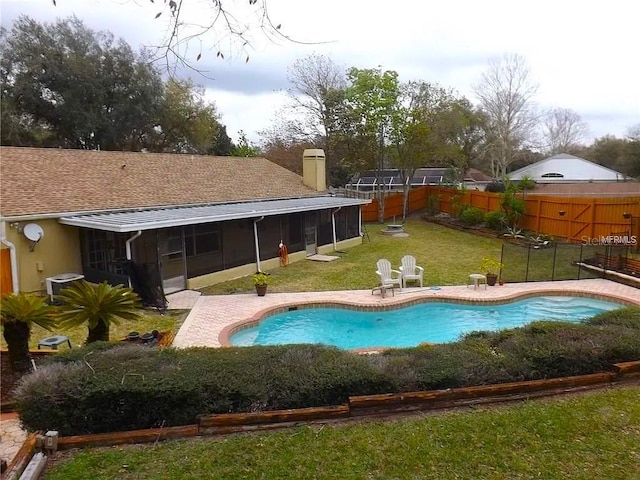 view of swimming pool featuring a sunroom, a yard, cooling unit, and a patio