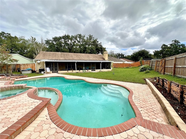 view of pool with an in ground hot tub, a patio, and a lawn