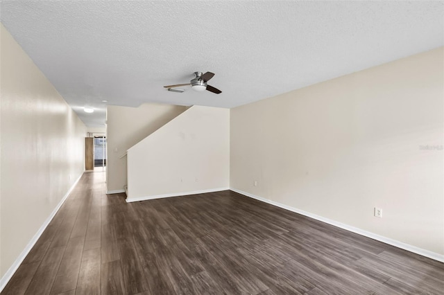 unfurnished living room featuring ceiling fan, a textured ceiling, and dark hardwood / wood-style flooring