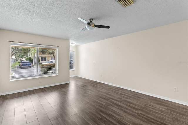 empty room with a textured ceiling, ceiling fan, and dark hardwood / wood-style flooring